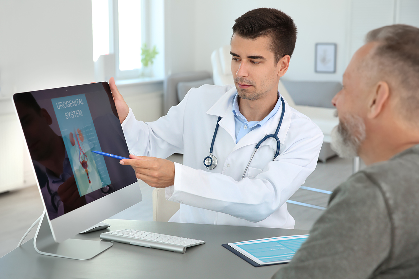 Background image : urologist showing a patient the urogenital system